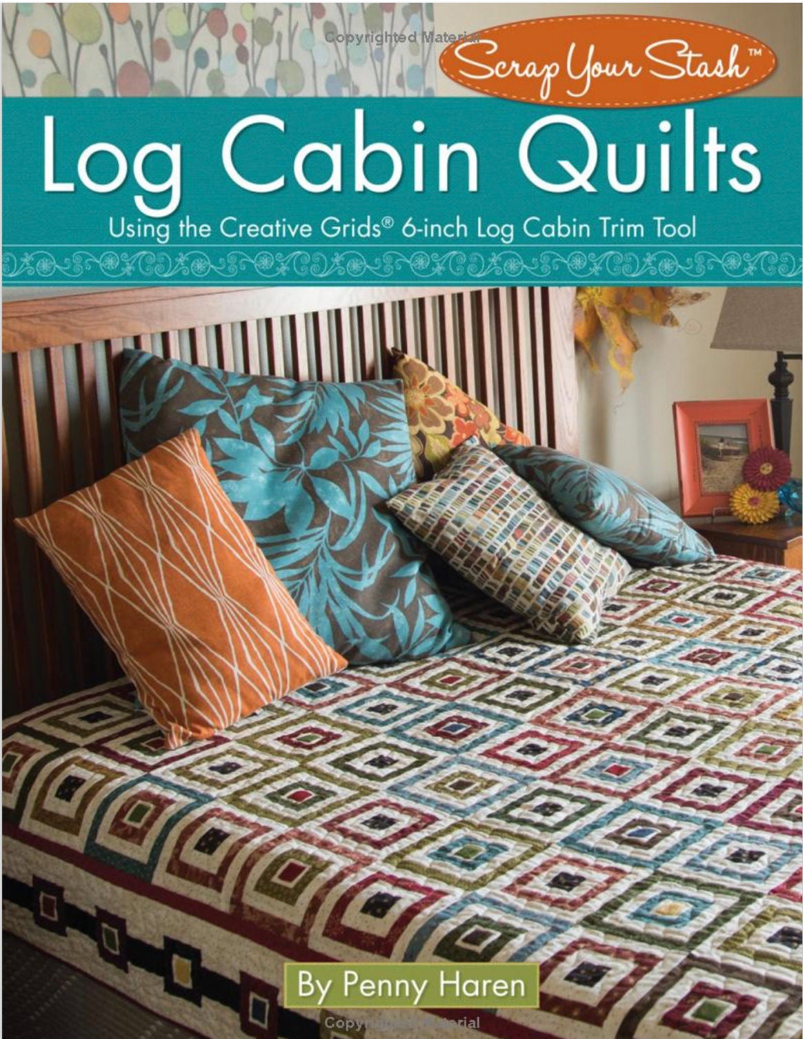 May include: A book titled 'Log Cabin Quilts' by Penny Haren. The book cover features a quilt made with a log cabin pattern in shades of red, green, blue, and brown. The quilt is displayed on a bed with pillows in various colors and patterns. The book cover also includes the text 'Scrap Your Stash' and 'Using the Creative Grids® 6-inch Log Cabin Trim Tool'.