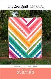 May include: The Zoe Quilt pattern by Erica Jackman for baby, lap, and twin sizes. The quilt features a colorful chevron design with stripes of pink, orange, yellow, green, and white.