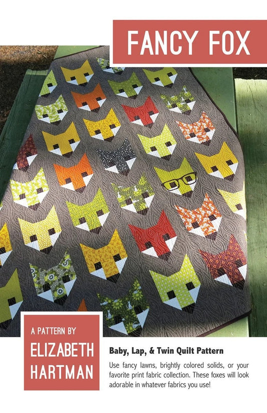 May include: A quilt pattern featuring a design of foxes with different colored fabrics. The pattern is called "Fancy Fox" and is by Elizabeth Hartman. The quilt pattern is for a baby, lap, or twin size quilt.